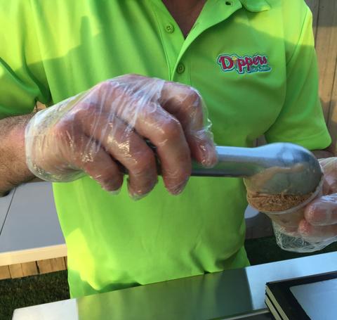 A Person Scooping Ice Cream onto a Cone