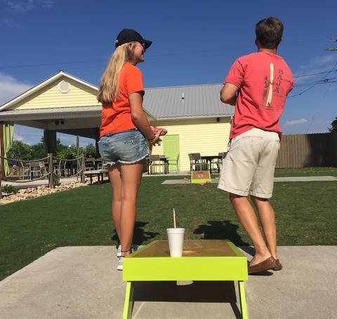 Two Adults Playing Corn-Hole