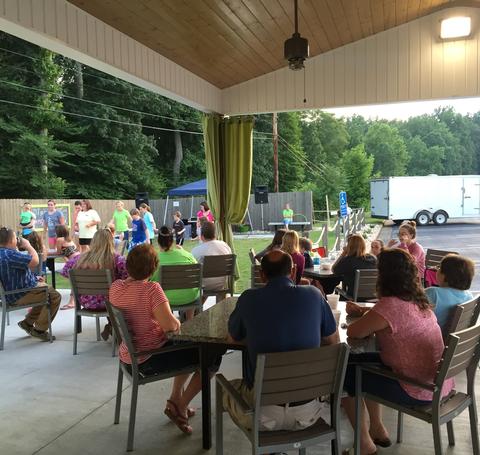 People sitting under an outdoor shelter.